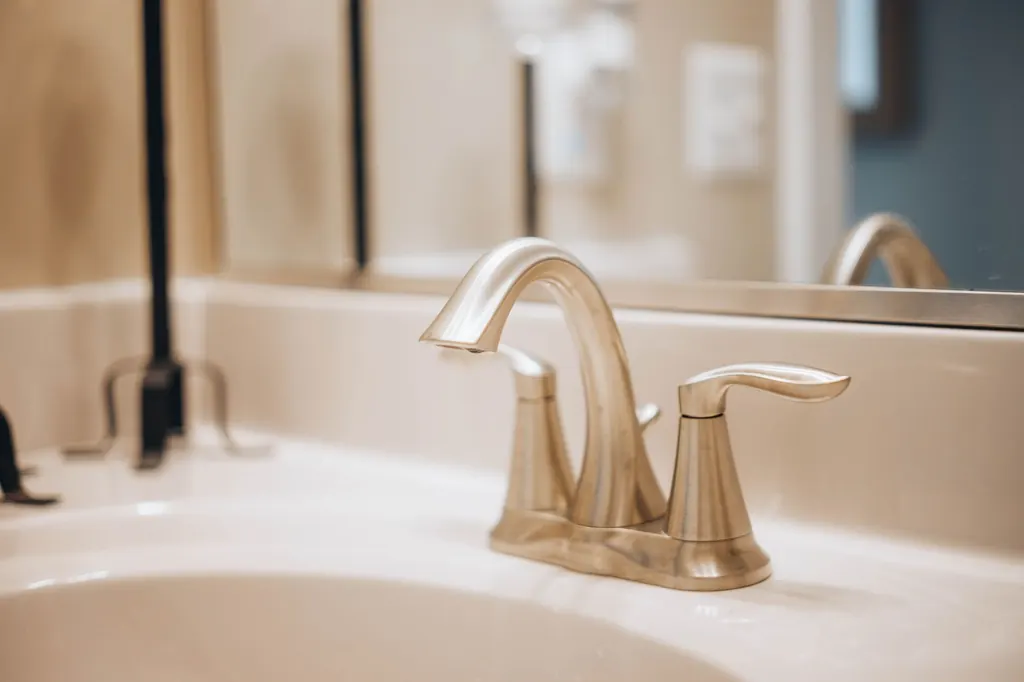 Hard water scale deposits on a bathroom faucet — signs of hard water in Assiniboia