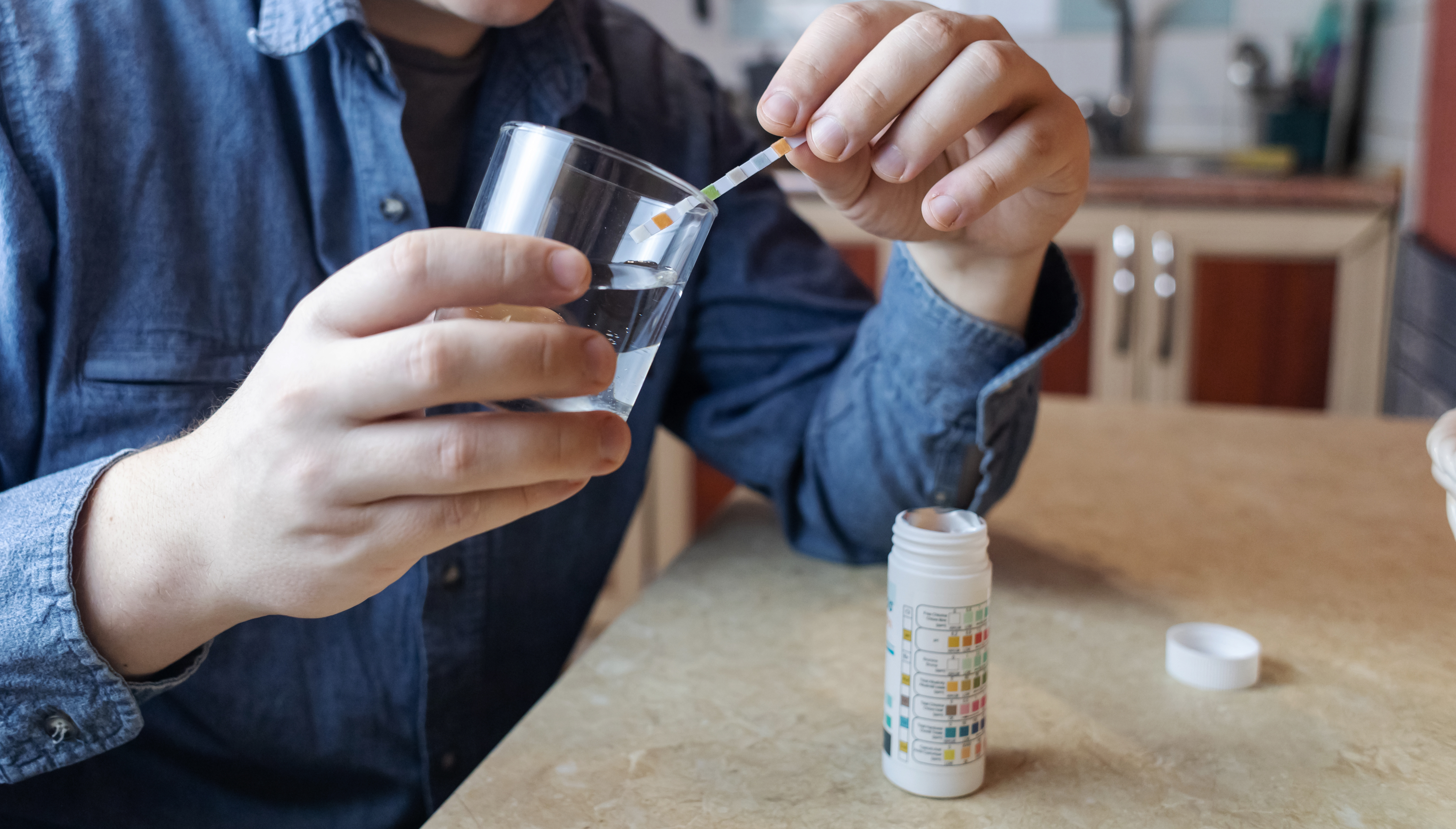 Water hardness test strip showing hard water reading — Austin